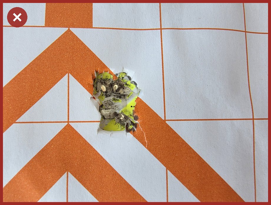 A tight close up of a single group of bullet holes, with none of the surrounding target sheet visible.